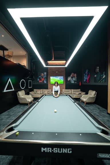 American pool table next to a lounge with sofas