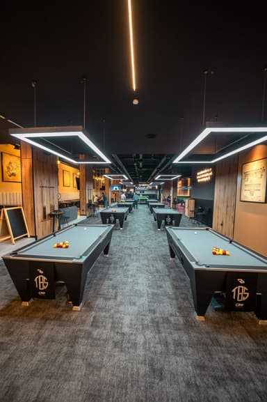 Rows of pool tables under hexagonal lights